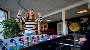Pige jubler over sejr i bordfoldbold i fællesrummet