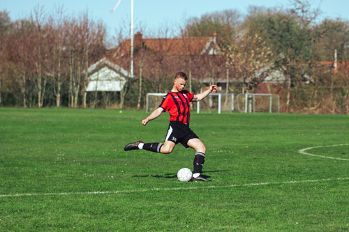 Efterskoleelev sparker til fodbolden under træningen på fodboldlinjefaget