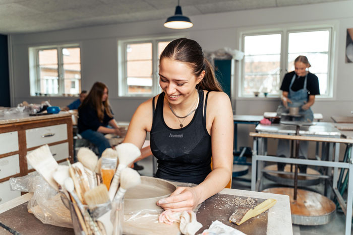 Pige på designlinjen drejer ler i timen