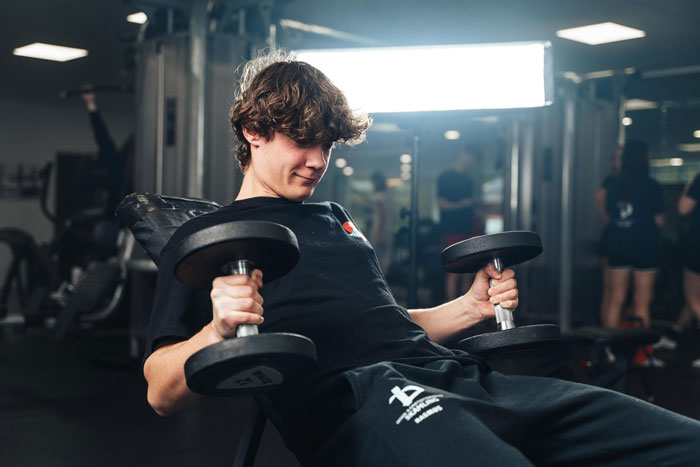 Fitnessrummet på efterskolen bliver udnyttet af en elev der løfter tunge vægte som en del af hans linjefag