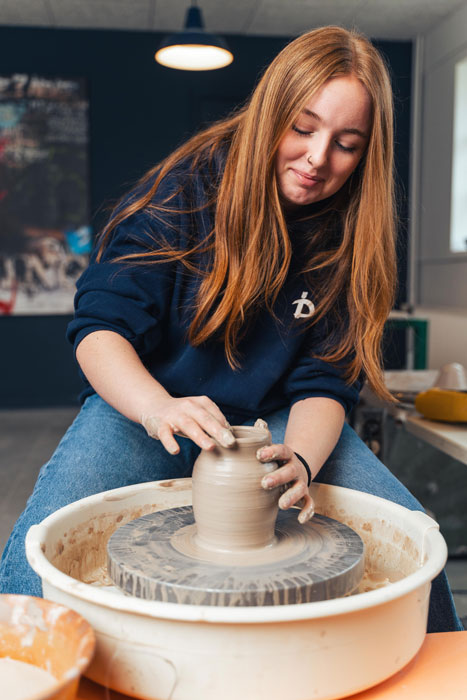 Elev drejer ler på drejebænk som en del af design linjefaget