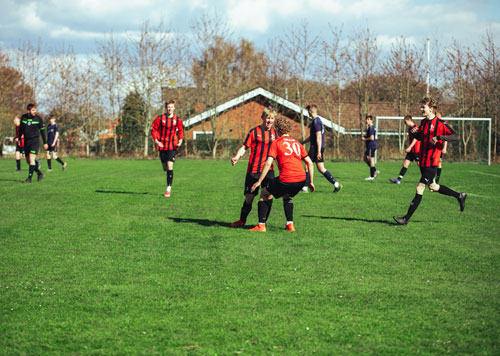 Drenge spiller fodbold på efterskole i jylland og solen skinner<br>