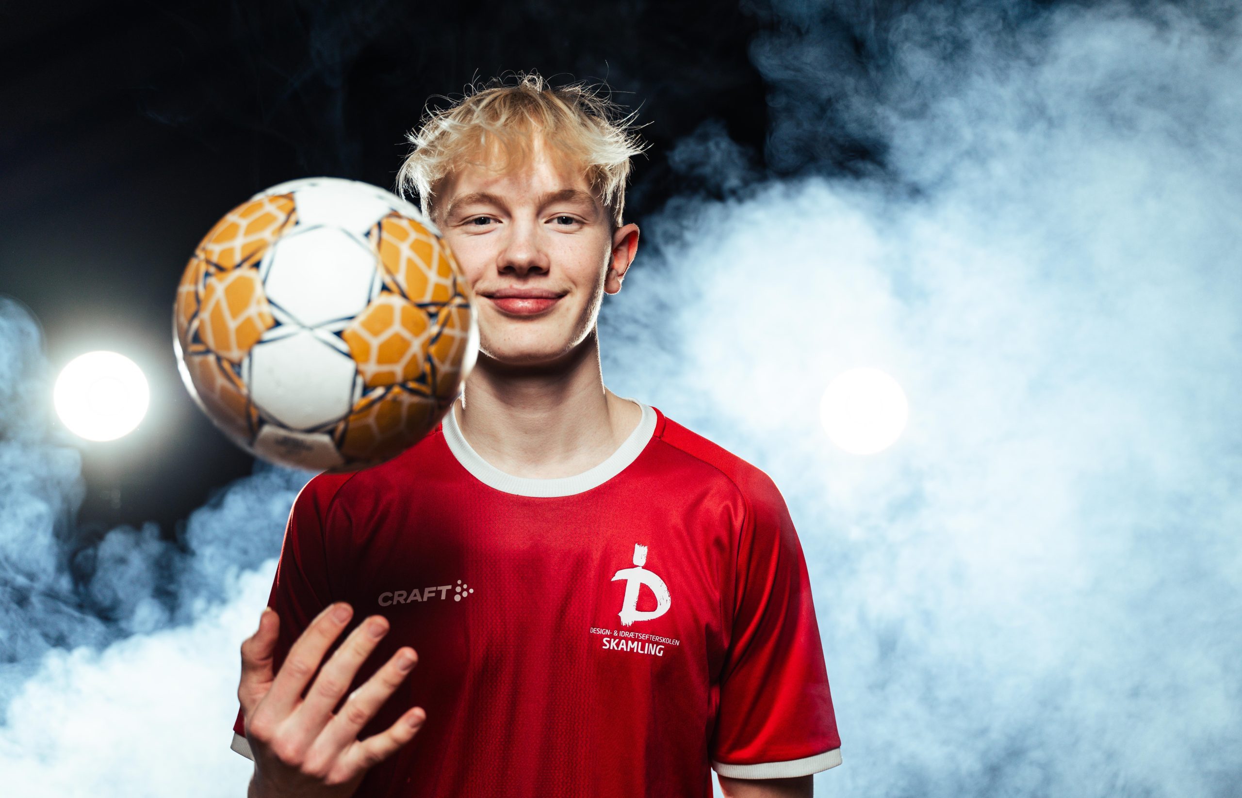 Hele håndboldholdet på Skamling efterskole holder om bolden og viser team spirit inden de skal på banen og spille kamp