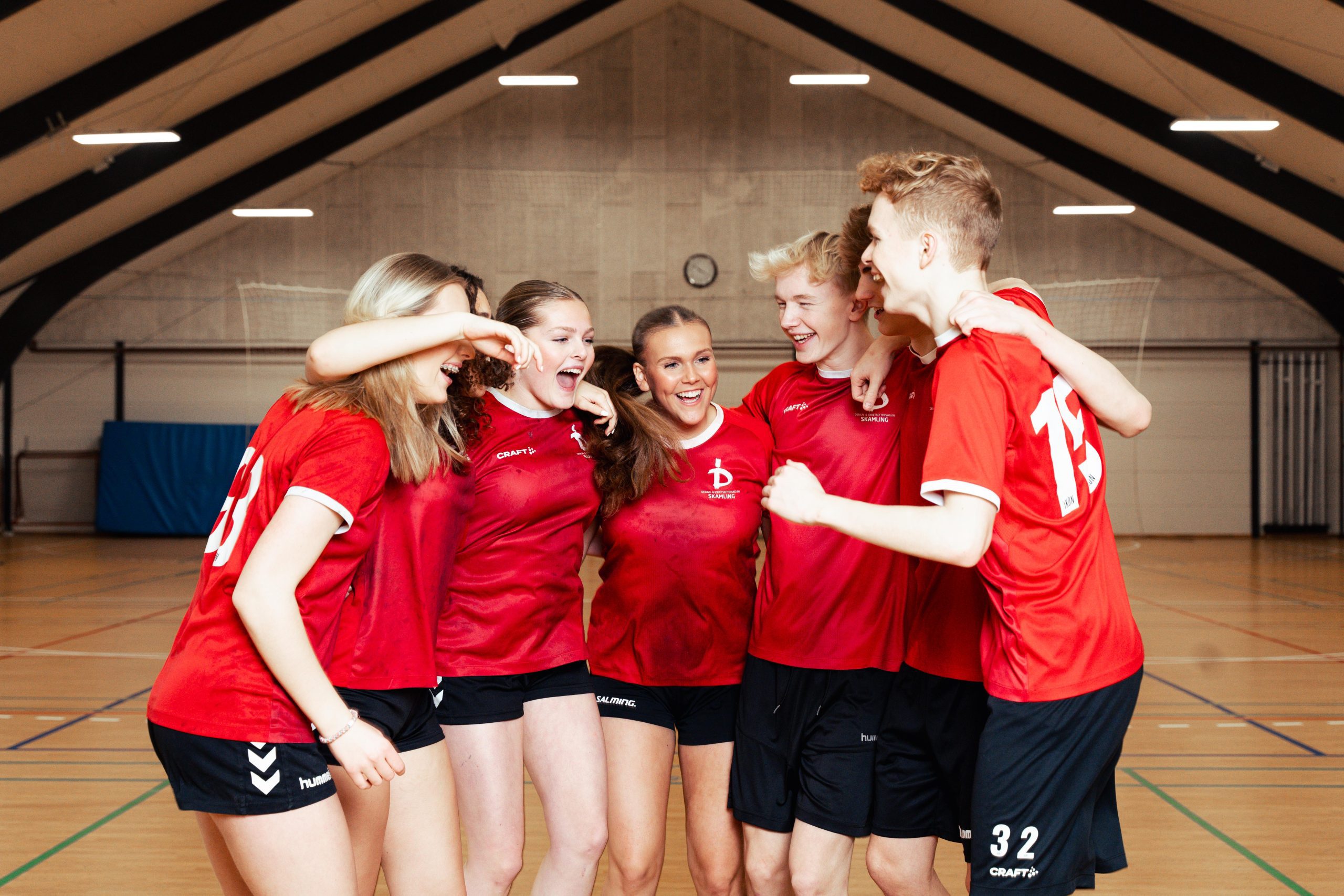 Håndboldholdet til holdbillede i hallen, alle smiler og glæder sig til endnu en træning